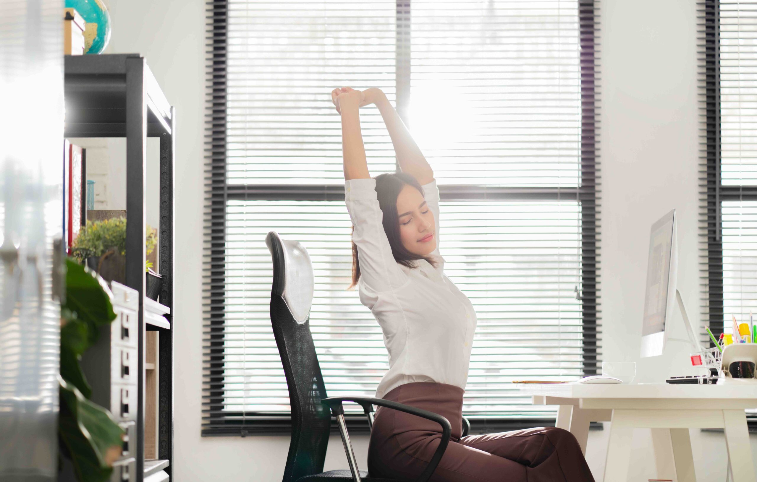 stanchezza-da-scrivania-ragazza-stretching-braccia-in-alto
